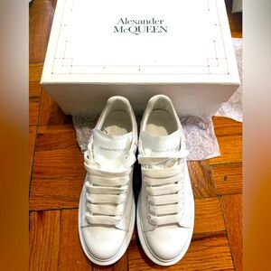 Alexander McQueen Classic White Lace-Up Sneakers with pink suede detailing.